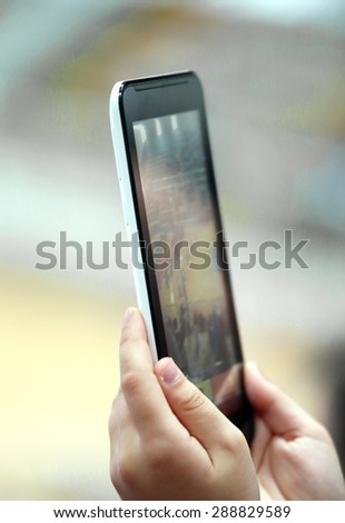 kid take photos with the smartphone technology during the performance of the athletes