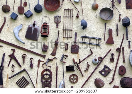 many ancient farming tools hanging on the wall