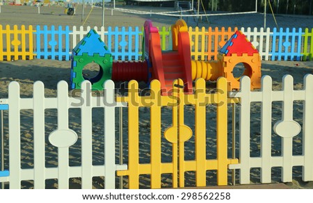colorful fence of a playground on the beach in summer by the sea