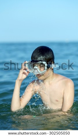young child swims in the sea with the diving mask in summer