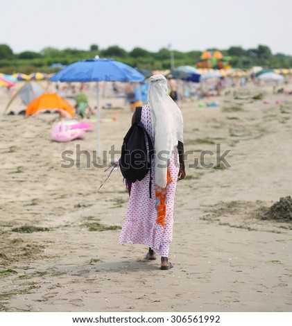 African woman Peddler Combs hair with colorful braids on the beach in summer