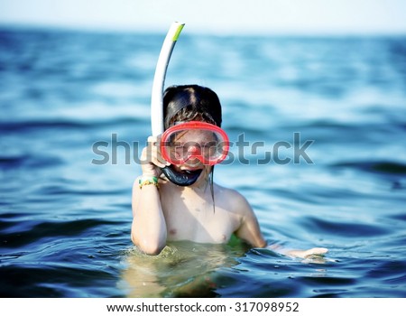 little girl with the diving mask and snorkel at sea in summer