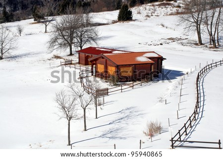 isolated mountain hut in the middle of the Meadow covered with white snow