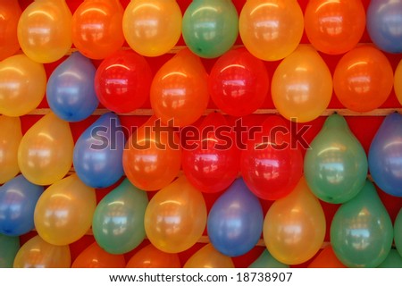 Rows of brightly colored balloons in a midway game at a county fair