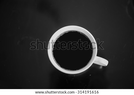 Cup of black coffee on a black table.