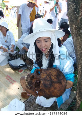 UBON RATCHATHANI, THAILAND - APR 19, 2009 : Unidentified woman holding skull of unidentified corpse for grave clearing activity on Apr 19, 2009 in Ubon Ratchathani, Thailand