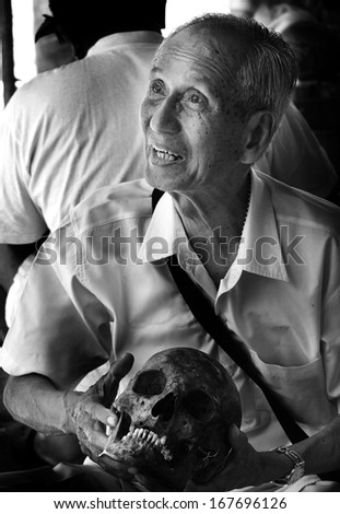 UBON RATCHATHANI, THAILAND - MAY 5, 2009 : Unidentified old man holding skull in grave clearing activity on May 5, 2009 in Ubon Ratchathani, Thailand