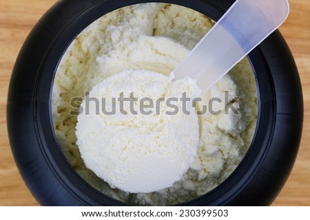 A scoop of fine Whey Protein Isolate Pure powder in a container