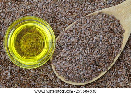 A bowl of cold pressed Linseed yellow oil on flaxseed background. flaxseed are seeds from flax plant.