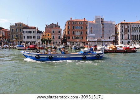 VENICE, ITALY - SEPTEMBER 2014: A man sitting in the SDA Express courier barge navigating the Grand canal in Venice,Italy on September 15, 2014. Barge is the  transportation to carry freight in Venice