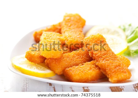 Plate of fish fingers with lemon and salad