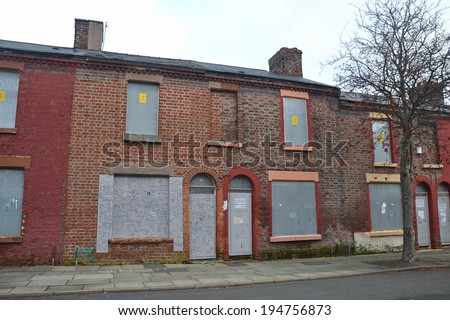 LIVERPOOL - December 10: derelict terraced houses in Toxteth, Liverpool, UK on December 10, 2013. The house with graffiti was the birthplace of Ringo Starr, drummer of The Beatles.