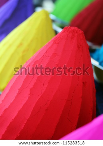 Piles and mounds of colorful dye powders for holy festival & other religious purposes being sold in indian market. The powders include kumkum(vermillion) in brilliant red, haldi in bright yellow, etc