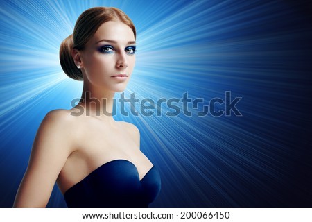 woman with evening makeup on a deep blue background with rays