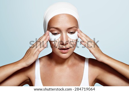 beauty woman with eye patches and lines showing an effect of