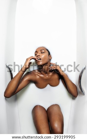 black woman from above in a bath with milk