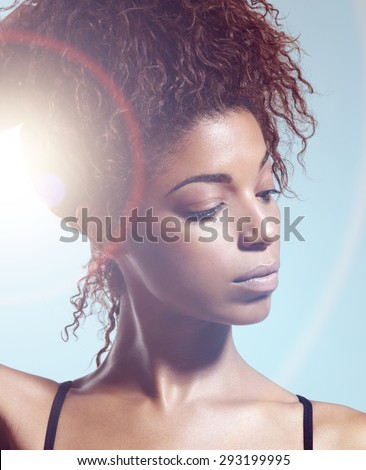 portrait of black woman watching aside with a sun flair