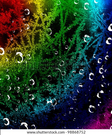Multi-colored bright frosty pattern with drops of water on a black background