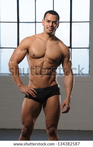 Male Fitness Model with six pack abs.   Bodybuilder fitness model posing in photo studio