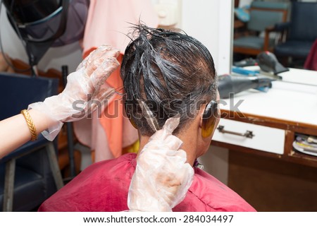 a middle aged Asian man making hair dye at a beauty salon