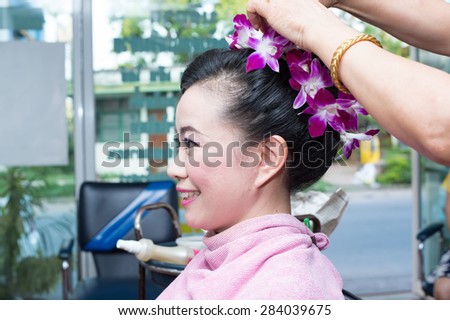 a beautiful woman making hair bun at a beauty salon