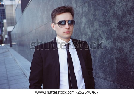 businessman in glasses goes along the wall. Portrait.