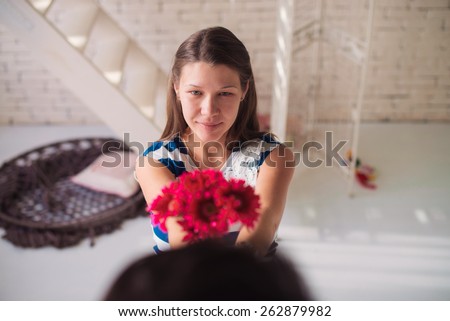 Happy girl giving flowers to her husband
