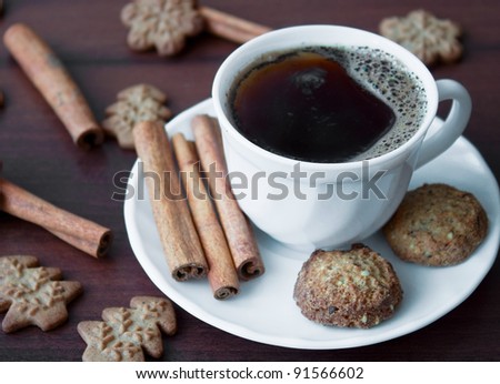 Coffe cup with cinnamon sticks and cookies