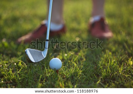 Golfer hitting the ball stick up close