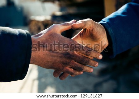 handshake of two workers at a factory close up