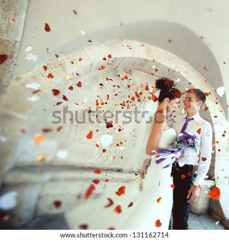 young groom embraces the bride at the festival, everyone is happy, flying confetti. Wedding festive theme