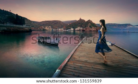 slim young beautiful girl in a blue dress at sea landscape
