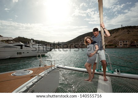 happy couple man and a pregnant woman on a yacht