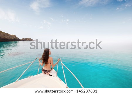 Beautiful young girl in bikini posing on a yacht at a sunny summer day
