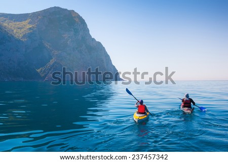Kayaking in the sea from back view .