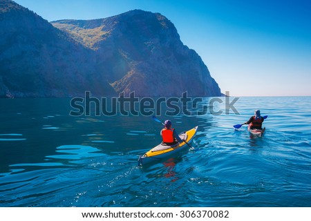 Kayaking. People swim in the sea kayak near the mountains. Adventures on the water.