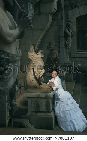 Beautiful bride beside chimeras and satire. Beauty and the Beast. Wedding theme.