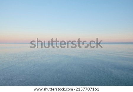 Calm water of the Black Sea against the backdrop of clear sunset sky in Ukraine. 商業照片 © 