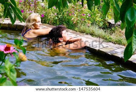 Two women are swimming in the pool at their summer cottage