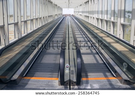 Tape escalator in glazed tunnel without people