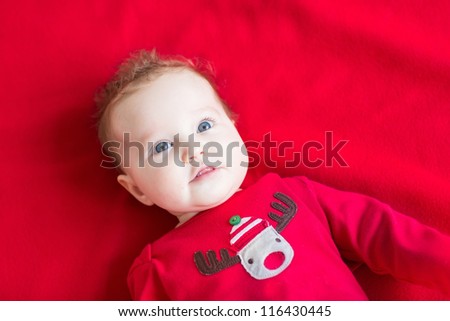 Sweet baby wearing a Christmas shirt on a red background
