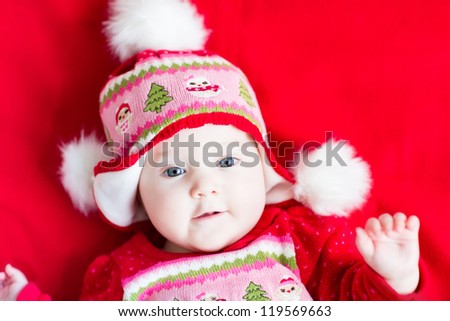 Sweet baby girl in a Christmas knitted dress and hat
