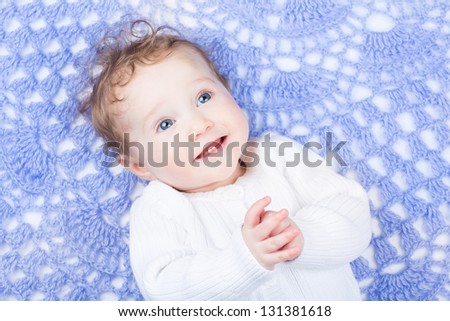 Cute little baby on a hand made knitted blanket