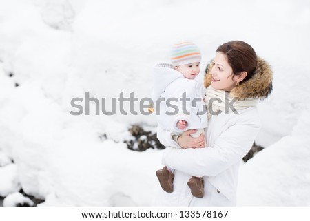 Mother and baby walking in a snowy park