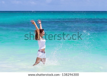 Attractive young woman jumping in the ocean