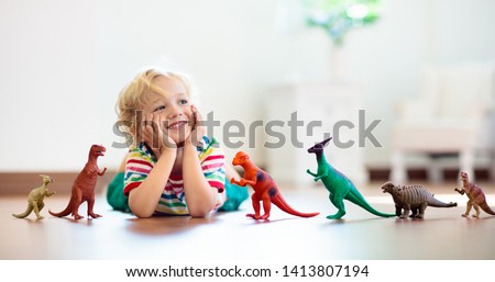 Similar – Image, Stock Photo little colored boy explores the feet of his little brother