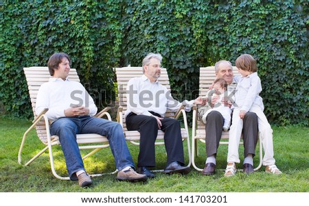 Big family of four generations relaxing in the garden