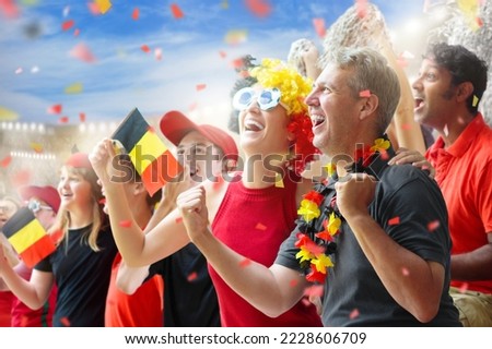 Belgium football fan on stadium. Belgian supporters watch soccer on outdoor field. Cheering team fans celebrate victory. Go Red Devils! Supporter in national jersey with country flag. Win celebration. Stock fotó © 