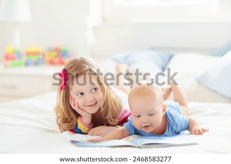 Foto Bild Zwei lustige Kinder spielen gemeinsam an einem Strand vor einer Meereswelle