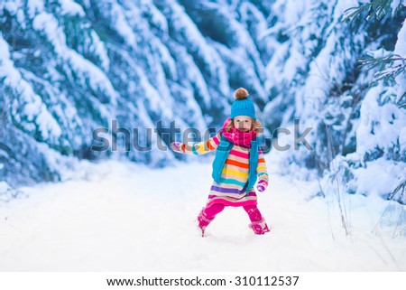 Little girl enjoying a sleigh ride. Child sledding. Toddler kid riding a sledge. Children play outdoors in snow. Kids sled in the Alps mountains in winter. Outdoor fun for family Christmas vacation.